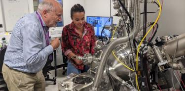El profesor David Jamieson y la doctora Maddison Coke de la Universidad de Manchester inspeccionan el sistema de haz de iones enfocado utilizado para purificar el silicio en la Universidad de Manchester.