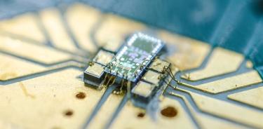 chip cuántico de silicio ePIC, montado en una placa de circuito impreso para pruebas y similar a una placa base dentro de una computadora personal.