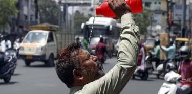 Un habitante de Nueva Delhi trata de refrescarse la cabeza para evitar un golpe de calor