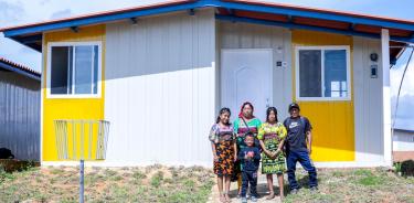 Familia guna al exterior de su nueva casa en Isber Yala, Panamá continental