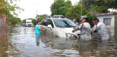 Una persona es auxiliada por elementos de la Guardia Nacional ante las severas iinundaciones en colonias de Chetumal.