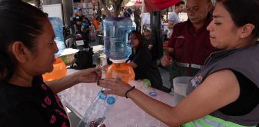 Personas mitigan el calor bebiendo agua gratuita en una carpa en la CDMX/
CUARTOSCURO/