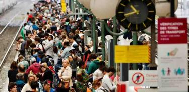 Numerosos pasajeros en los andenes de una estación de París.