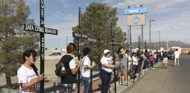 Imagen del 3 de agosto de 2023 de personas cargando cruces durante un acto en homenaje a las víctimas del tiroteo en Walmart/