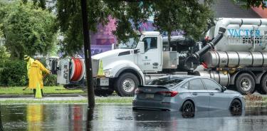 Un automóvil quedó atrapado en una calle inundada después de la lluvia de la tormenta tropical Debby en Savannah, Georgia