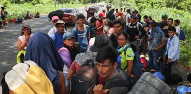 Migrantes descansan a un costado de una carretera en Chiapas/