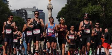 Corredores durante la edición XL del Maratón de la Ciudad de México en 2023 pasando frente al Ángel de la Independencia.