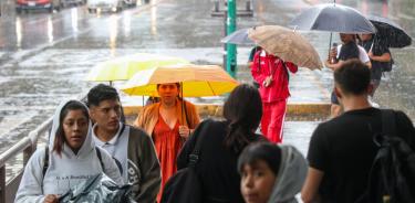 CIUDAD DE MÉXICO, 18AGOSTO2024.- Una intensa lluvia sorprendió a los capitalinos cerca de las cinco de la tarde. En la imagen personas se cubren de la lluvia con paraguas e impermeables en la estación Plaza de la República. FOTO: MOISÉS PABLO/CUARTOSCURO.COM