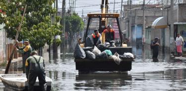 Con ayuda de un tractor se lleva a cabo el retiro de basura en varias calles inundadas en Chalco//CUARTOSCURO/