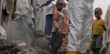 Un trabajador de la Cruz Roja fumiga con clorina un campamento de desplazos en Goma, República Democrática del Congo, para frenar el brote de mpox