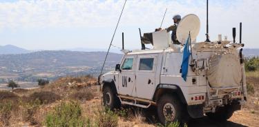 Soldado español observa desde una tanqueta de la ONU la frontera entre Israel y Líbano, al fondo la localidad israelí de Meyula