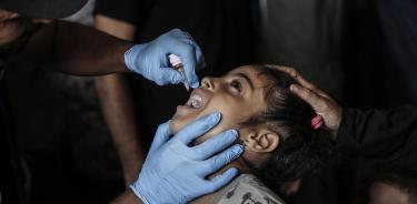 Una enfermera pone la vacuna oral a una niña en el campo de refugiados de Deir al Balah, en el sur de Gaza