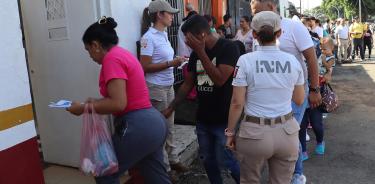 Migrantes esperan en una fila para resolver su situación migratoria este lunes, en la ciudad de Tapachula. EFE