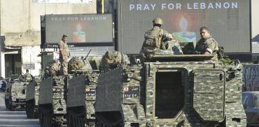 Espectaculares piden rezar por Líbano frente a un convoy de tanquetas del Ejército libanés en Beirut